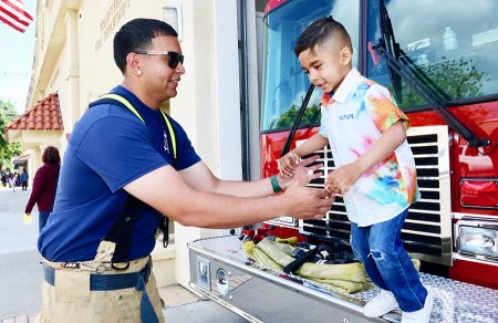 A Lemoore Volunteer Fireman gives a helping hand to a local youngster.